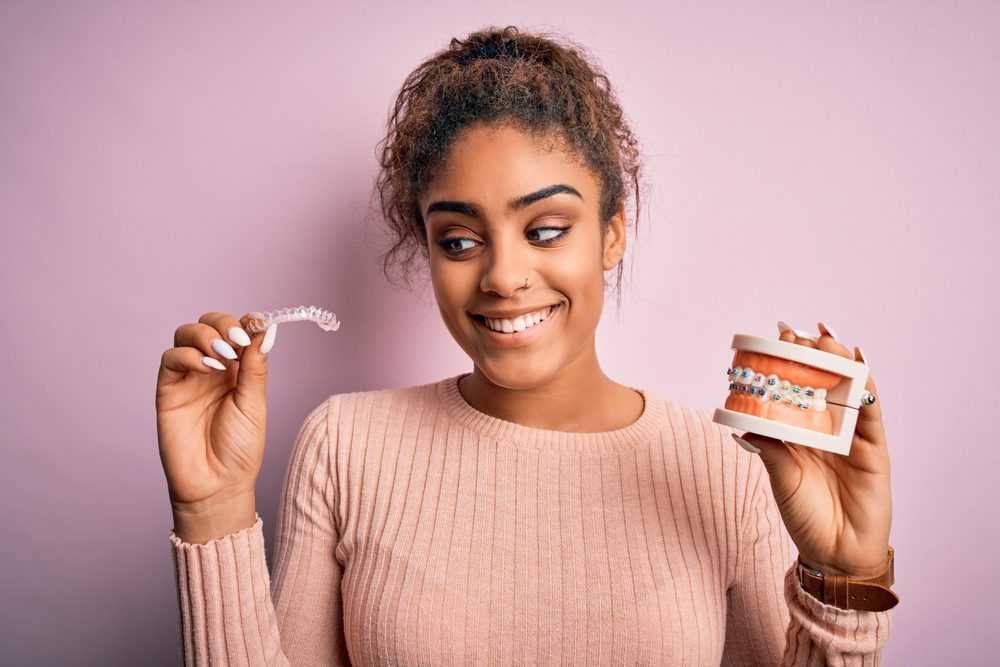 Young,african,american,woman,smiling,happy,holding,professional,orthodontic,denture Young,african,american,woman,smiling,happy,holding,professional,orthodontic,denture